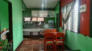 圣维森特Charity Pension House的厨房设有绿色的墙壁和桌椅