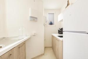 卡斯特里尼亚诺德尔卡波LecasinediCo` by BarBarHouse的白色的厨房配有冰箱和水槽
