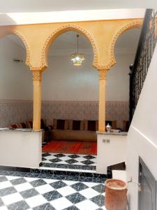 马拉喀什Les Riads Nour Resorts- Marrakesh Escape的一间设有柱子和 ⁇ 格地板的房间
