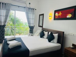 亭可马里里约纳海滩酒店的一间卧室设有一张床和一个美景窗户。
