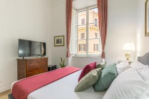 罗马Gentile Suites的一间卧室设有一张床、一台电视和一个窗口。