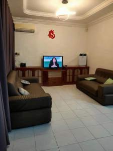 诗巫Sibu kulas homestay的客厅配有2张沙发和1台平面电视