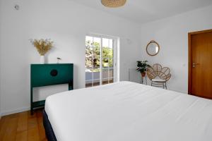 塞辛布拉Beautiful Villa in Sunny Lagoa的白色的卧室设有一张大床和一个窗户