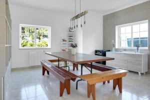 塞辛布拉Beautiful Villa in Sunny Lagoa的一间厨房,内设桌子和长凳