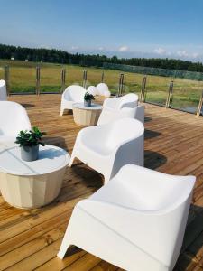 SvencelėAitvarai 41的木制甲板上配有白色的椅子和桌子