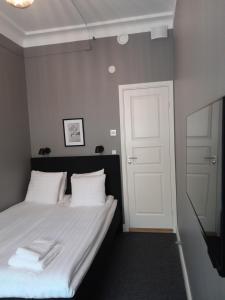 斯德哥尔摩Birka Hotel的卧室配有带白色床单和白色门的床。