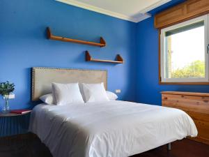 维拉加尔西亚·德·阿劳萨Villa Remoan的一间蓝色的卧室,配有白色的床和窗户