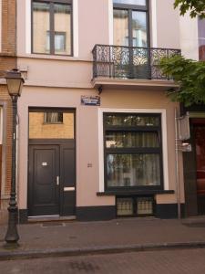 布鲁塞尔迷笛公寓酒店的一座带黑色门和阳台的建筑