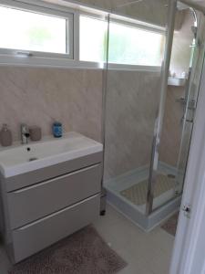 巴恩斯特珀尔Hill's View的浴室配有白色水槽和淋浴。