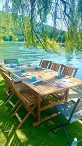 吕斯坦Pieds dans l'eau Private Wellness Bordure de Meuse的湖畔木餐桌和两把椅子