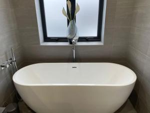 PoyntonLuxury Canalside Apartment with Hot Tub的带窗户的浴室内的白色浴缸