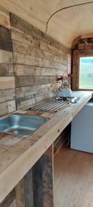 吉斯本Little Middop Farm Camping Pods的一个带水槽和木墙的厨房