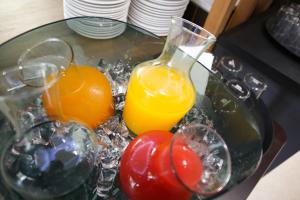 洛迦诺Hotel Bellavista Locarno的玻璃桌,带两杯果汁和西红柿