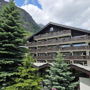 采尔马特Le Mirabeau Resort & Spa的带阳台和两棵树的建筑