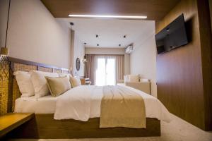 奥弗里安Kasta Beach Hotel的卧室配有一张大白色床和窗户