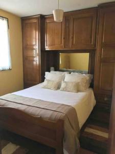 蒙考Recanto do Lameiro的一间卧室配有一张带木制橱柜的大床