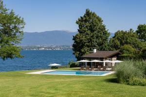日内瓦Park Villa Geneva - Swiss Hotel Apartments的水边的房屋,设有游泳池