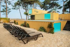 纳扎雷Ohai Nazaré Outdoor Resort的海滩上一排躺椅