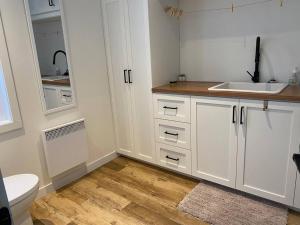 蒙洛里耶Chalet avec Spa Baskatong的白色的厨房配有白色橱柜和水槽