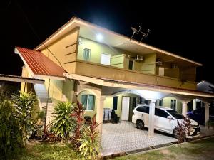 珍南海滩Maze Roomstay Langkawi的夜间停在房子前面的汽车