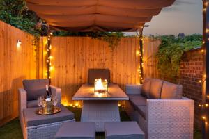 卡迪夫Exquisite Cardiff Apartments- with Garden Lounge & Games Room的天井配有桌椅和灯
