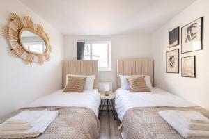 卡迪夫Exquisite Cardiff Apartments- with Garden Lounge & Games Room的带镜子的客房内的两张单人床