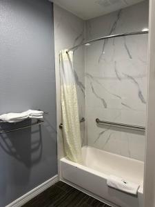 休斯顿Atlantis Inn Suites的带淋浴、浴缸和盥洗盆的浴室