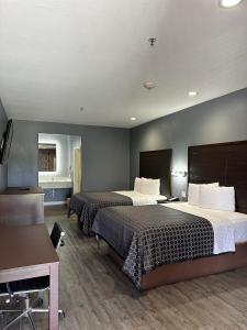 休斯顿Atlantis Inn Suites的酒店客房配有两张床和一张书桌