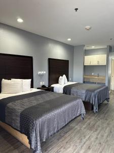 休斯顿Atlantis Inn Suites的一间酒店客房,房间内设有两张床