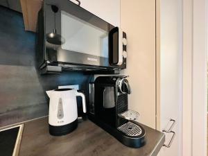 格拉茨APSTAY Serviced Apartments - Self Check-in的厨房柜台上方的咖啡壶上方的微波炉