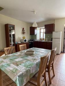 Anilio PelionCamellia Guesthouse的一间带桌椅的厨房和一间带冰箱的厨房