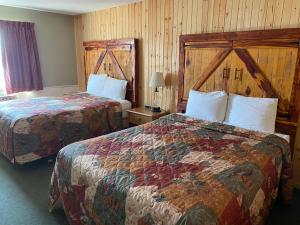 ClarindaCelebrity Inn的配有木墙的酒店客房内的两张床