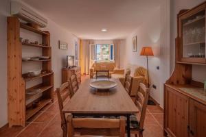 拉伊斯莱塔德尔摩洛Apartamento Cala Grande的一间带木桌和椅子的用餐室