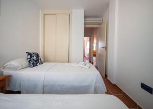 拉伊斯莱塔德尔摩洛Apartamento Cala Grande的一间卧室设有两张床,一扇门通往浴室