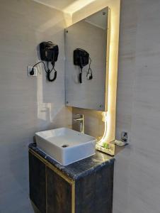 达卡Hotel Royal Bengal的浴室设有白色水槽和镜子