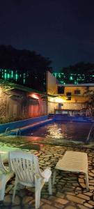 安吉利斯2 Hotel Saleh的夜间坐在泳池旁的白色长凳