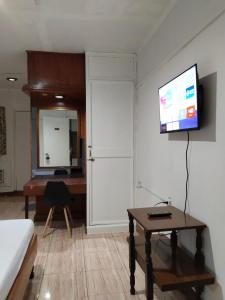 安吉利斯2 Hotel Saleh的客厅配有书桌和墙上的电视