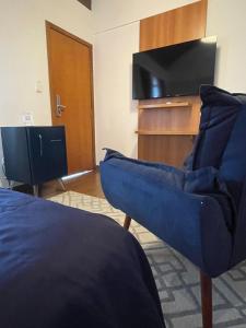 佩尼多Hotel Aromas de Penedo的客厅配有电视和蓝色沙发。