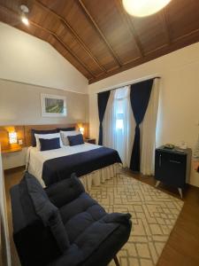 佩尼多Hotel Aromas de Penedo的一间卧室配有一张特大号床和一张沙发