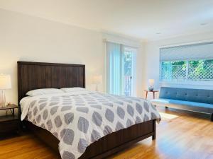 米尔布雷3 bedroom residential home in the lovely town near SFO San Francisco的一间卧室配有一张大床和一张蓝色的沙发