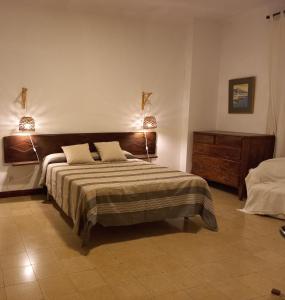 莱斯卡拉L'Escala - Pintor Massanet的一间卧室配有一张大床和两盏灯。