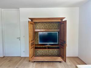 布雷根茨Seeparkvilla – Wohlfühlen am See und im Grünen的客房内的木制娱乐中心设有电视