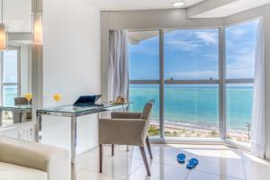 马塞约Hotel Brisa Praia Pajuçara的客厅配有书桌,享有海景