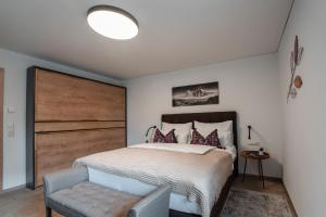 卡普伦Haus Kulala的一间卧室配有一张大床和木制床头板