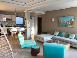 布兹尼盖Bouznika plage costa的带沙发和桌子的客厅以及厨房。