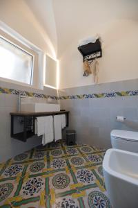 潘泰莱里亚Kirani Resort的一间带卫生间的浴室,铺有瓷砖地板。