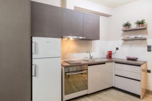 约阿尼纳Twelve Studios的厨房配有白色橱柜和冰箱。