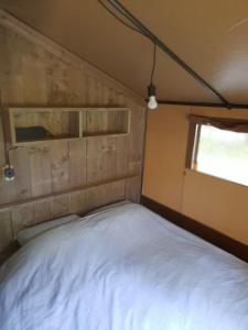 VledderSafaritent Sarek, Wolvenspoor 10的卧室配有一张位于拖车内的白色床