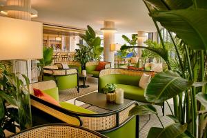 布鲁克林Hotel Indigo - Williamsburg - Brooklyn, an IHG Hotel的大堂设有绿色家具和植物