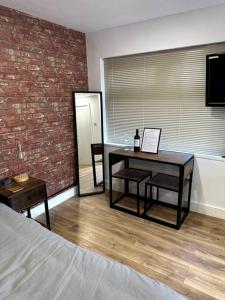 海斯Perfect stay with Dallas Studio的一间卧室设有桌子和砖墙